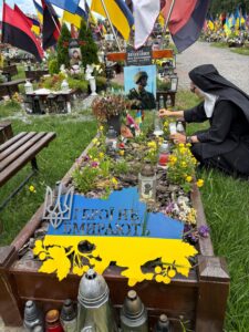 Mother Klara visiting the grave of a Ukrainian soldier.