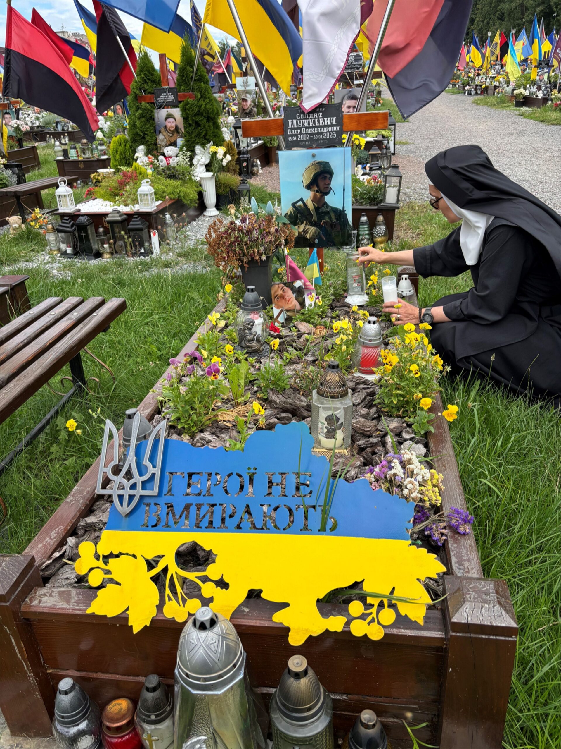 Mother Klara visiting the grave of a Ukrainian soldier.